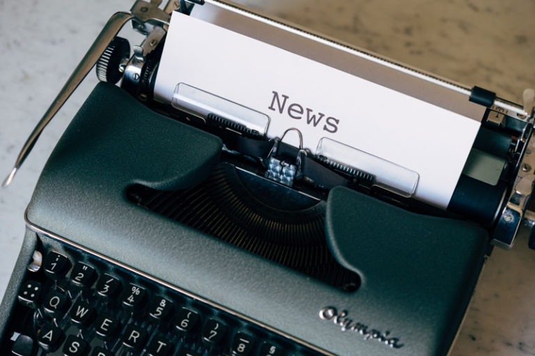 a typewriter with paper that says news in it